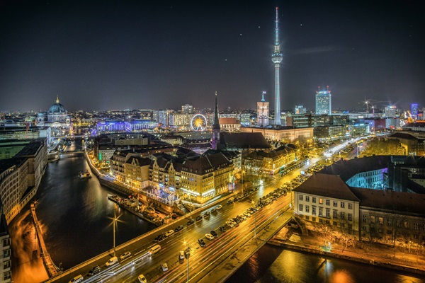 Foto en contrapicado de la ciudad de Berlín durante la noche, con las luces encendidas.